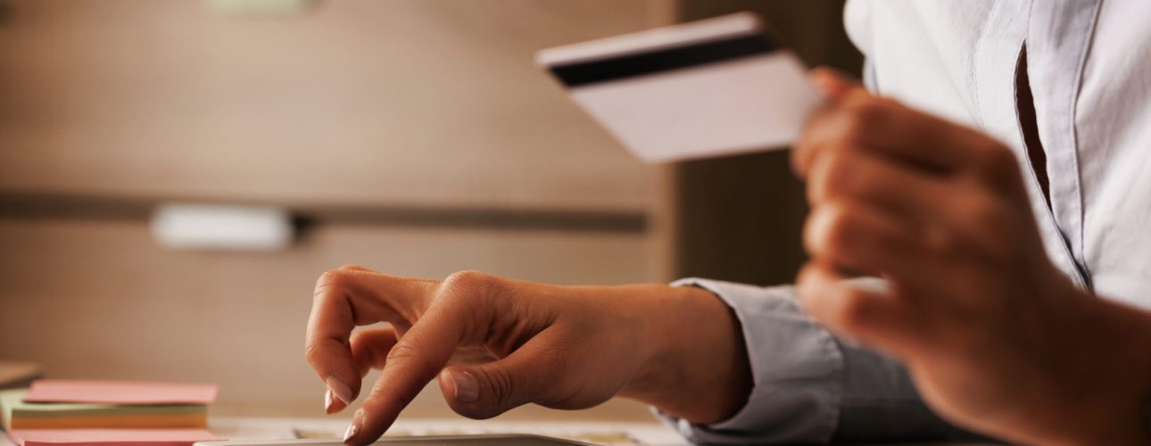 Close-up of businesswoman using digital tablet and credit card while checking her online bank account.